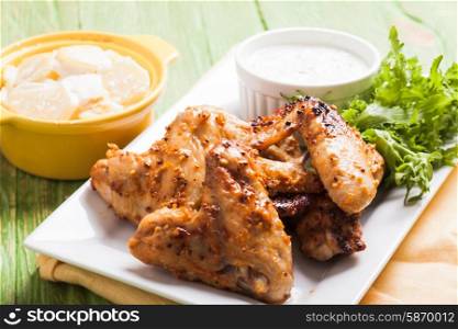 Roasted Chicken wings and tzatziki sauce on a plate. Chicken wings