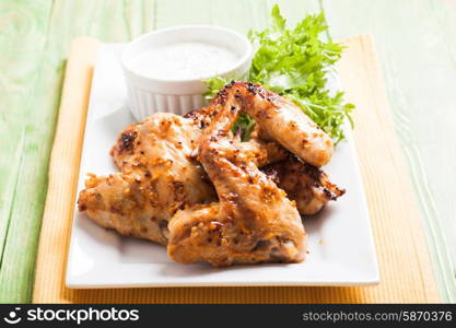 Roasted Chicken wings and tzatziki sauce on a plate. Chicken wings