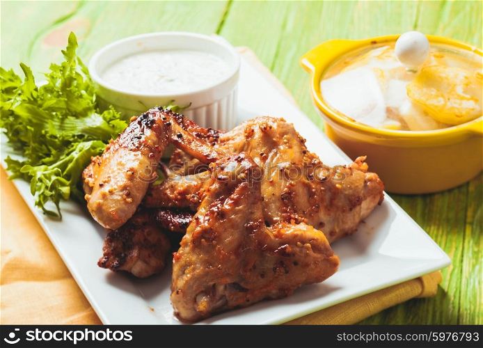 Roasted Chicken wings and tzatziki sauce on a plate. The Chicken wings