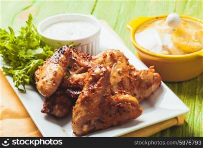 Roasted Chicken wings and tzatziki sauce on a plate. The Chicken wings