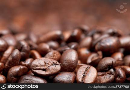 roasted coffee beans background with focus foreground