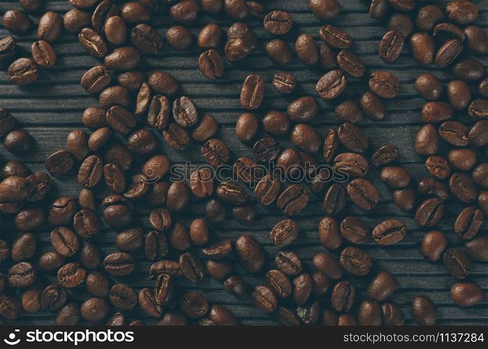 roasted coffee beans. coffee beans on the table wood dark background. soft focus.