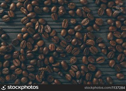 roasted coffee beans. coffee beans on the table wood dark background. soft focus.