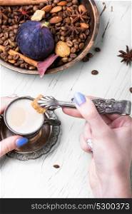 roasted coffee beans. cup of coffee in hands and tongs with cane sugar on a coffee background