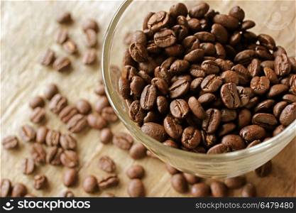 roasted coffee beans in glass on wooden table