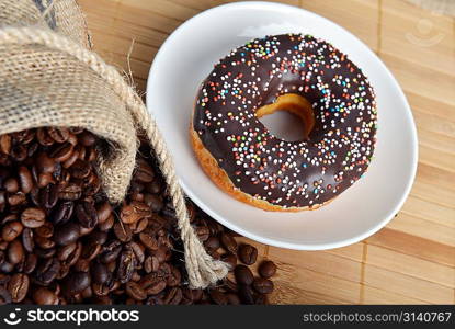 Roasted coffee beans in jute sack on hessian background