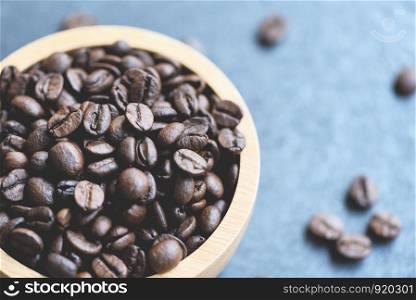 Roasted coffee beans on wooden bowl and dark background