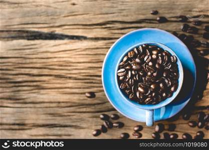 Roasted coffee beans put in a blue coffee cup.