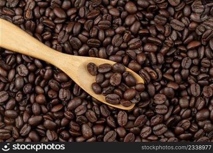 roasted coffee beans with wooden spoon, seeds of coffee