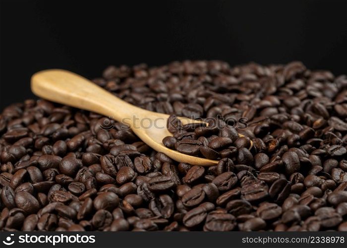 roasted coffee beans with wooden spoon, seeds of coffee