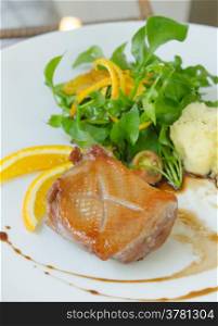 Roasted duck breast served with mashed potatoes and orange , fresh salad and white wine sauce
