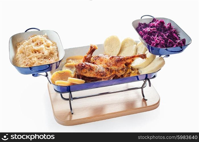Roasted duck with dumplings, red and white cabbage on white background
