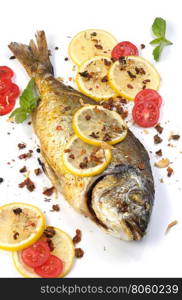 roasted fish Dorado with lemon slices and tomatoes flavored spices