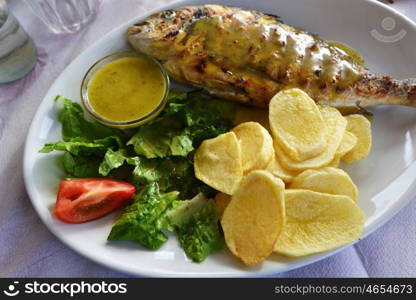 roasted fish, potato and vegetables on dish