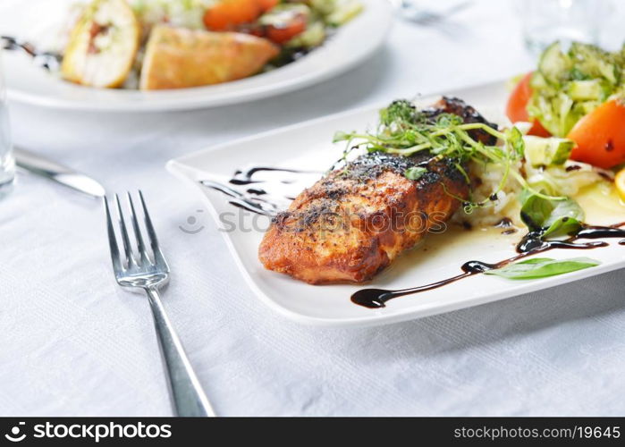 roasted fish, rice and vegetables on dish