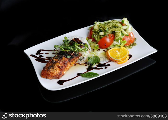 roasted fish, rice and vegetables on dish