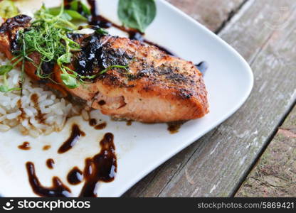 roasted fish, rice and vegetables on dish