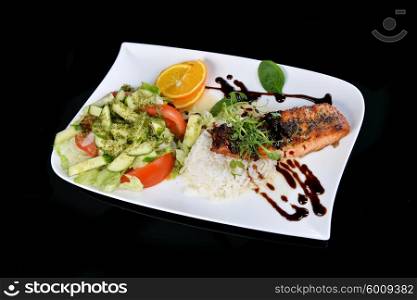 roasted fish, rice and vegetables on dish
