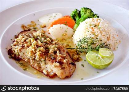 roasted fish served with fried rice fresh lemon and vegetable