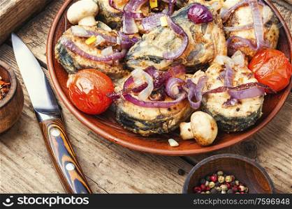 Roasted fish with grilled vegetables on wooden table.Roast fish. Tasty baked fish on plate