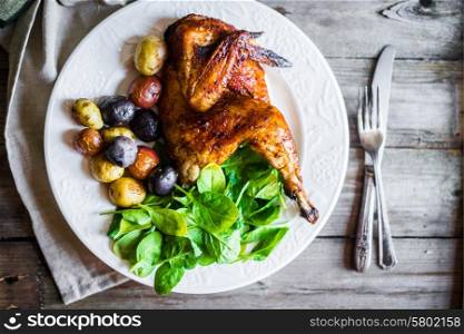 Roasted half chicken with potatoes and spinach