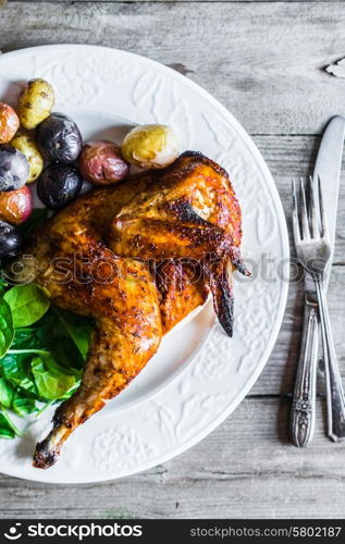 Roasted half chicken with potatoes and spinach