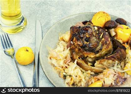 Roasted knuckle of pork with cabbage and beer. Traditional German recipe.. Pork knuckle eisbein and beer