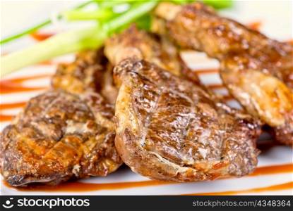 Roasted lamb meat tied with scallion closeup