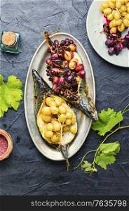 Roasted mackerel or scomber in grape berry sauce. Fish food. Grilled mackerel with grapes