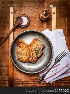 Roasted marinated pork steaks served on rustic kitchen table, top view