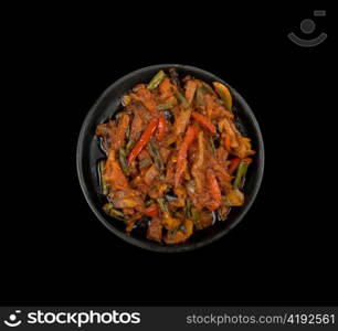 Roasted meat and vegetables at pan on a black background