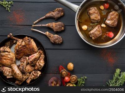 roasted meat in a pan on a black wooden background. the food, the view from the top