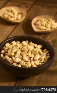 Roasted peeled unsalted peanuts in rustic bowl, photographed with natural light (Selective Focus, Focus one third into the peanuts in the bowl)