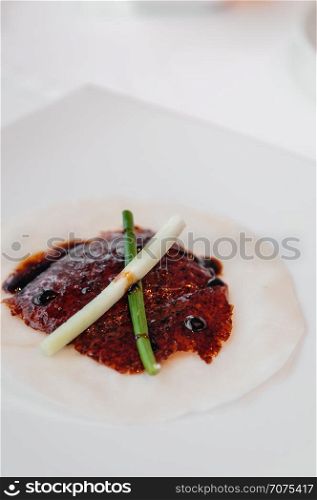 Roasted Peking duck or Beijing duck crispy skin with sweet Hoisin sauce, spring onion and fresh cucumber on steamed pancake. Close up shot