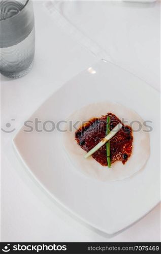 Roasted Peking duck or Beijing duck crispy skin with sweet Hoisin sauce, spring onion and fresh cucumber on stemed pancake. Top view shot