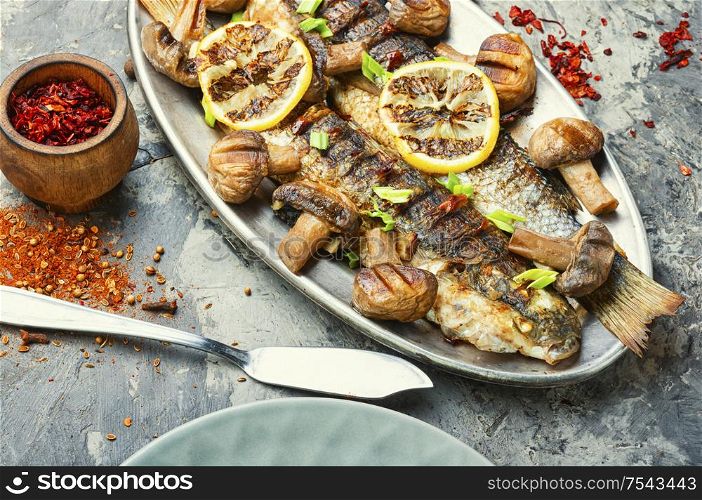 Roasted pelengas fish with mushrooms and lemon.Sea food.Grilled fish with champignon. Grilled fish on tray