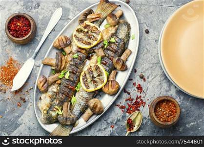 Roasted pelengas fish with mushrooms and lemon.Sea food.Grilled fish with champignon. Grilled fish on tray