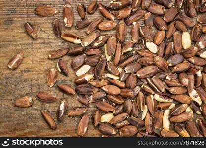 roasted pili nuts, grown in Philippines, against a grunge wood background