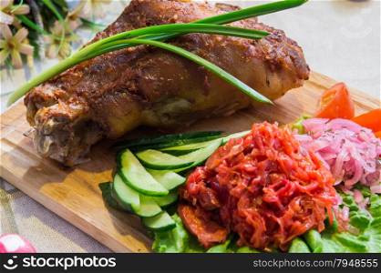 roasted pork knuckle with vegetables and herbs