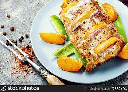 Roasted pork loin with baked persimmon.Roasted pork and persimmon on plate. Grilled barbecue pork