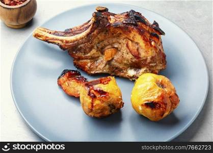 Roasted pork meat steak with quince.Delicious fried meat. Steak on the bone.