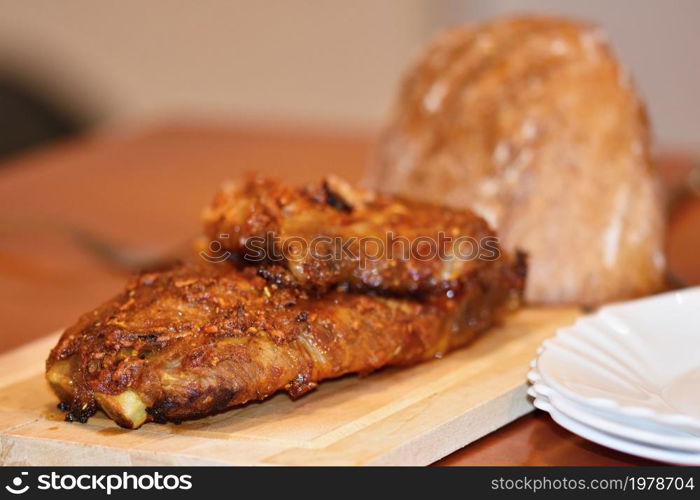 Roasted pork ribs. On wooden background bread.