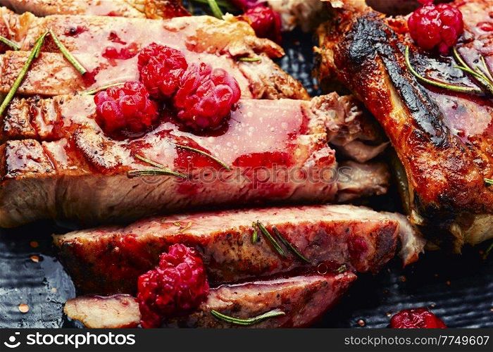 Roasted pork steak on a plate. Juicy steak sliced and berry jam. Pork steak with berry sauce.