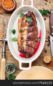 Roasted pork with cherry filling.Baked pork in a baking dish. Baked meat on a wooden background