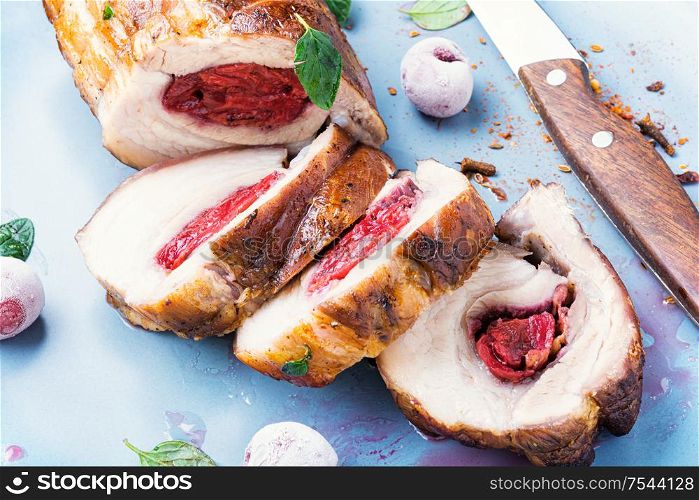 Roasted pork with cherry filling on plate.Baked pork,closeup. Meat loaf with cherry
