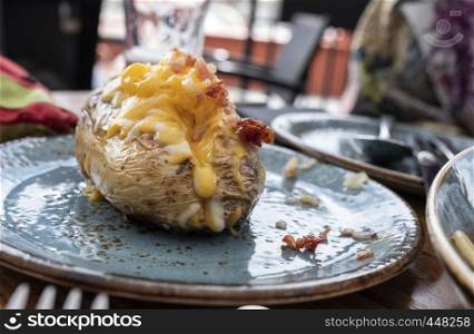 roasted potato stuffed with cheddar cheese on blue plate