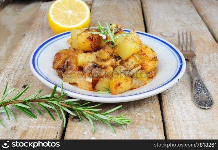 Roasted potatoes and rosemary country style on wooden background