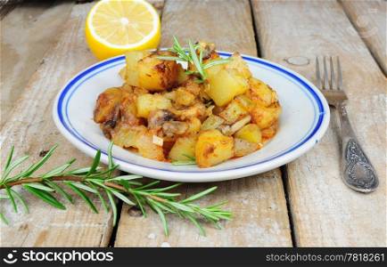Roasted potatoes and rosemary country style on wooden background