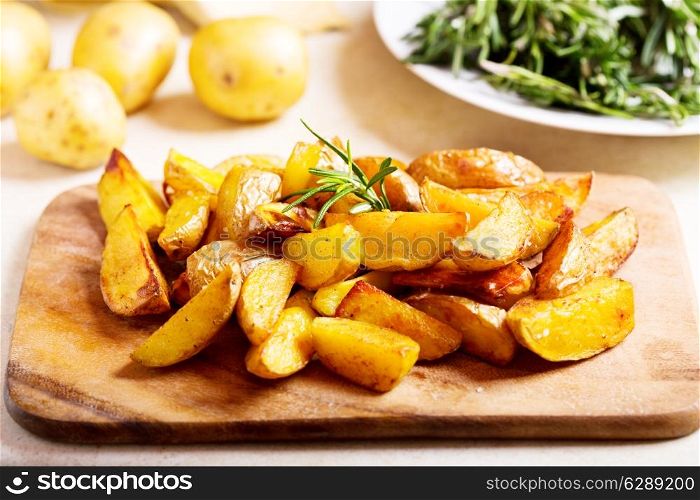 roasted potatoes with rosemary on wooden board