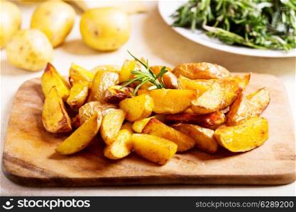 roasted potatoes with rosemary on wooden board